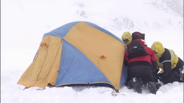 徒步旅行者到达时，一场暴风雪打在雪地里的一个帐篷上。视频素材