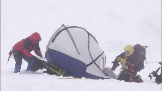 一支登山队在暴风雪中努力寻找避难所。视频素材