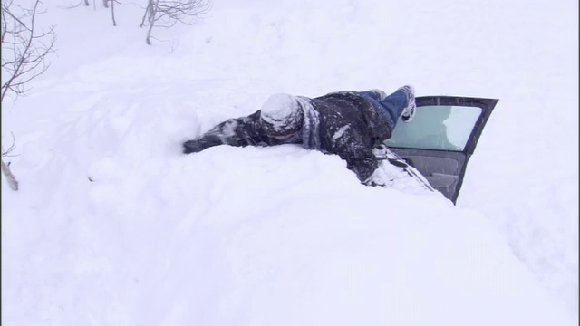 一个男人刮掉越野车上的雪，这样就能看见了。视频素材