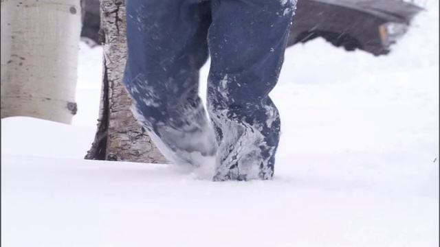 一名男子在暴风雪中艰难地穿过厚厚的积雪。视频素材