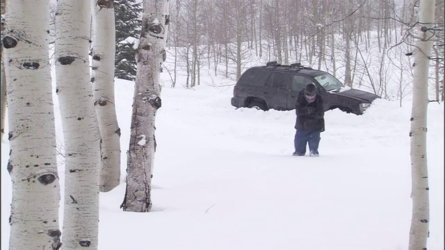 一名男子在暴风雪中艰难地穿过厚厚的积雪时摔倒了。视频素材