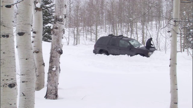 一名男子在暴风雪中艰难地离开一辆SUV。视频素材