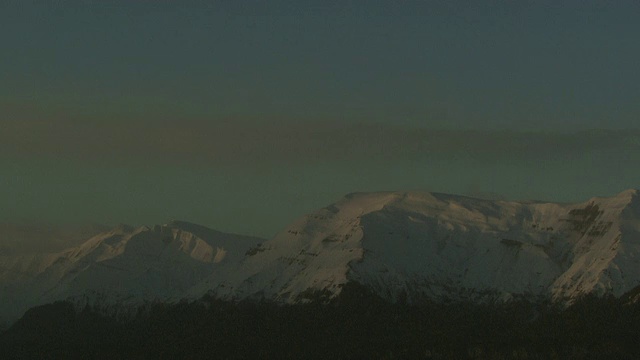 在阿拉斯加的雪山上空，云层呈条状。视频素材