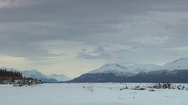 云朵飘过阿拉斯加的雪山和平原。视频素材