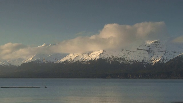 低低的云层在阿拉斯加的雪山和海湾上翻腾。视频素材