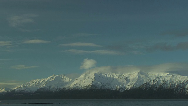 缕缕的云漂浮在雪山之上。视频素材