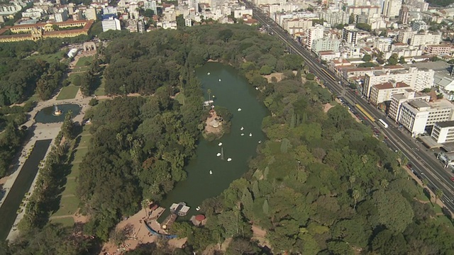 巴西阿雷格里港，一条高速公路经过一个树木繁茂的公园和湖泊。视频素材