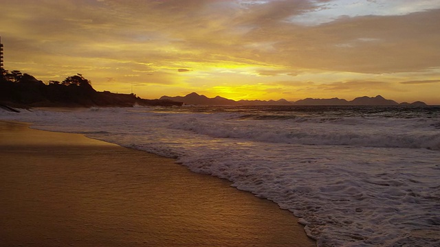 慢动作，从天空倾斜下来，海浪从魔鬼的海滩滚滚而来(Praia do Diabo)视频素材