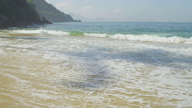 在里约热内卢的红海滩上，海浪在沙滩上慢慢的退去和流动。视频素材