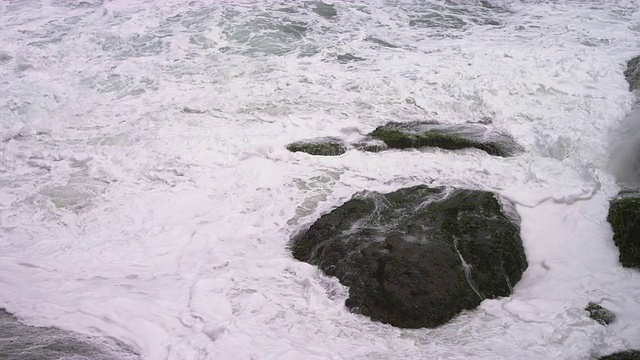 在巴西里约热内卢的海滩上，缓慢的海浪拍打着岩石视频素材