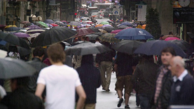 慢镜头显示街道上挤满了撑着雨伞的人视频素材