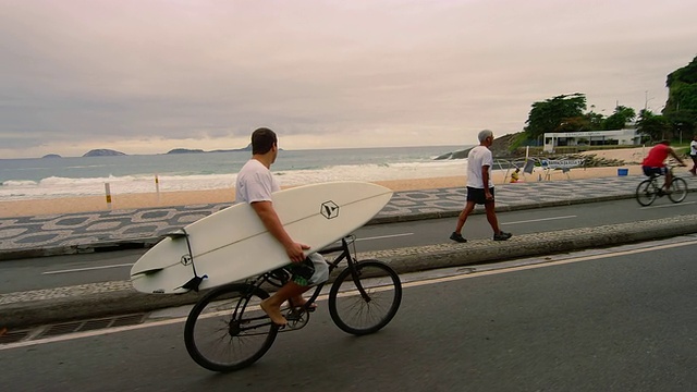 里约热内卢DE janeiro - 6月23日:2013年6月23日，里约热内卢，一名男子在伊帕内玛海滩附近骑着冲浪板视频素材