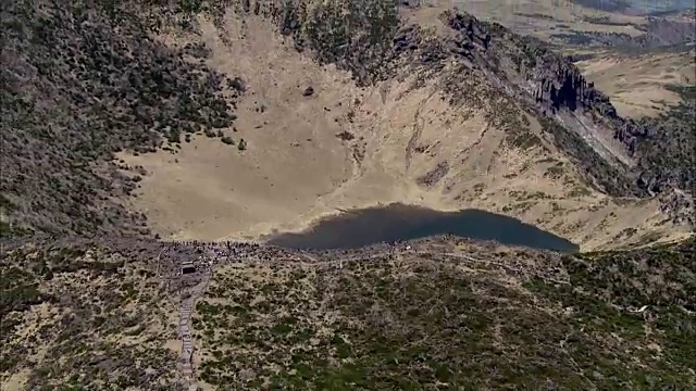 白诺丹火山口湖(哈拉山山顶)与登山者鸟瞰图视频素材