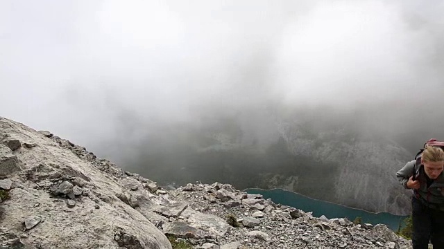 男徒步者攀登山脊，上面的山，薄雾视频素材