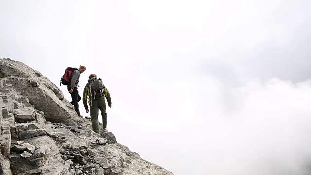 男徒步者攀登山脊，上面的山，薄雾视频素材