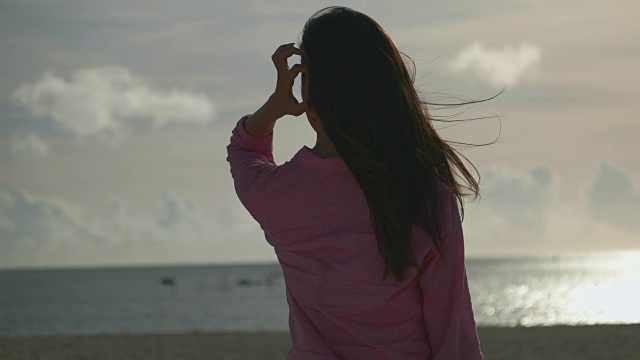 年轻的日本女性站在那里望着大海。视频素材