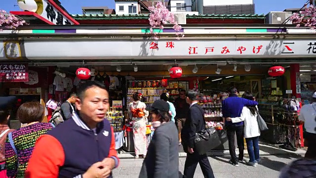 镜头捕捉到两名穿着Furisode(日本长袖和服)的年轻女子站在中见世街礼品店前。视频素材