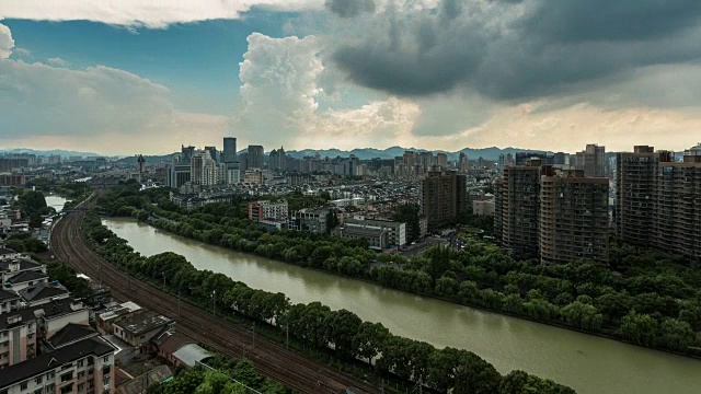 4K延时:列车在暴雨云层中驶过杭州市中心的建筑视频素材