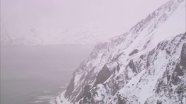 雾笼罩着荒野地区被冰雪覆盖的沿海山脉。视频素材