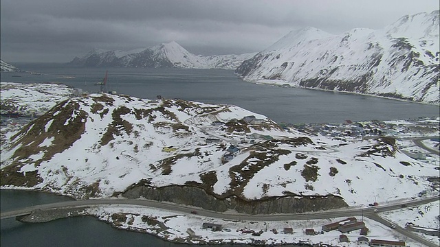 在荷兰港(Dutch Harbor)附近的一个海滨社区，房子点缀在积雪的山坡上。视频素材