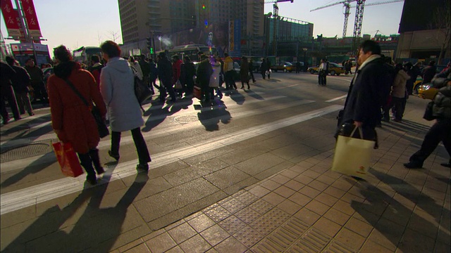 行人穿过北京一条繁忙的街道。视频素材