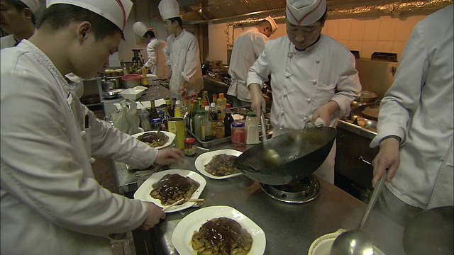 在餐馆里，厨师把食物盛在盘子里。视频素材