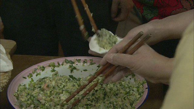 妇女们用筷子包饺子。视频素材