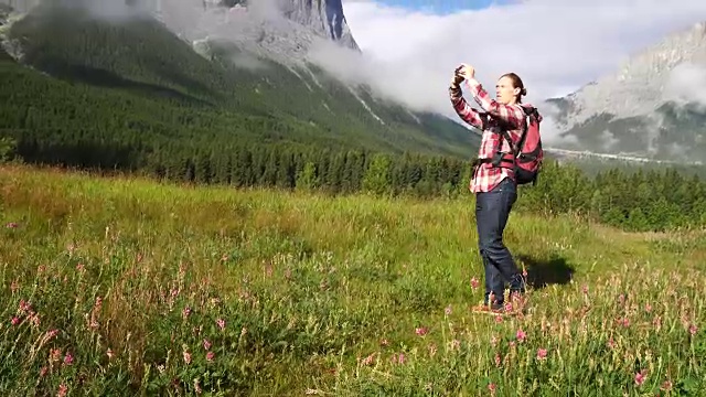 徒步旅行者穿过草地，眺望群山和森林视频素材