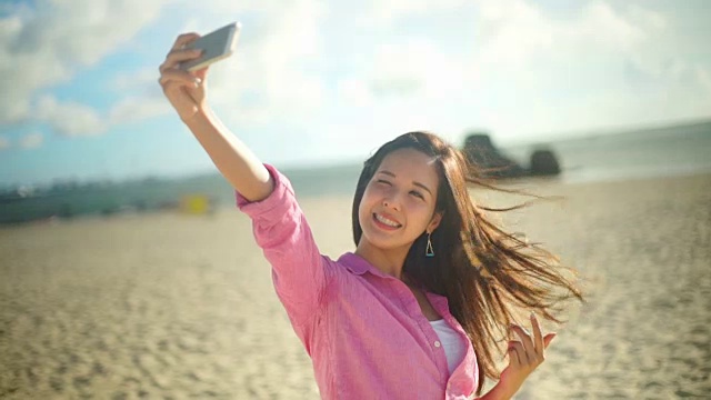 日本年轻女性在海滩自拍。视频素材