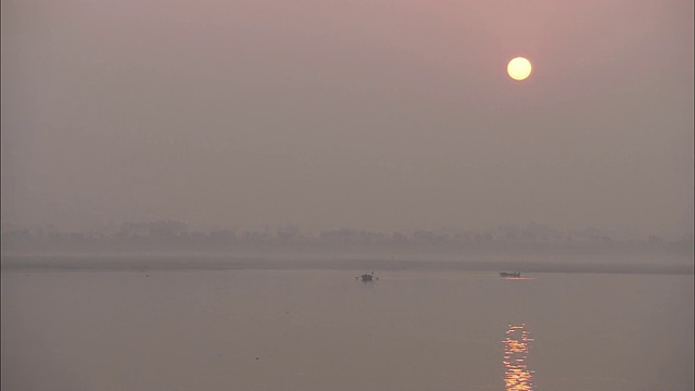 金色的太阳把昏暗的光线投射在海洋的地平线上。视频素材