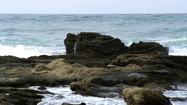 版权免费股票视频片段海浪和岩石海岸拍摄在以色列4k与红色。视频素材