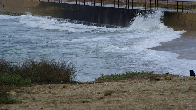 海浪撞击海岸屏障的版权免费股票视频片段在以色列拍摄4k与红色。视频素材