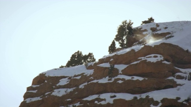 滑雪者从雪山悬崖上向前翻转的慢镜头视频素材