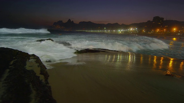 慢镜头，海浪在夜晚撞击依帕内玛海滩视频素材