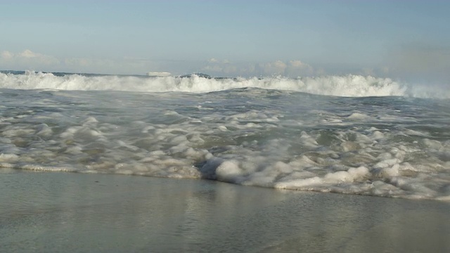 海浪翻滚着冲进海滩。视频素材