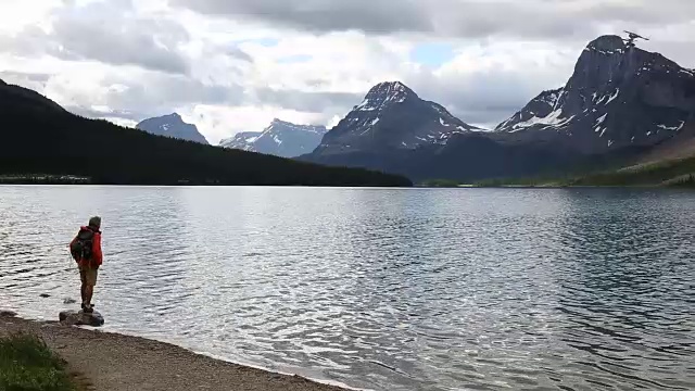 徒步者走到湖边，望向雪山视频素材