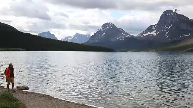 徒步者从湖边走出来，望向雪山视频素材