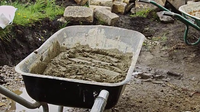 用手推车装满水泥的建筑者视频素材