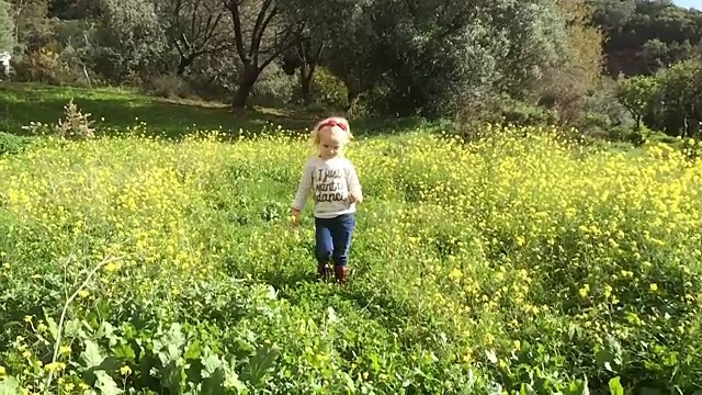 年轻女孩在花圃里走向摄像机视频素材