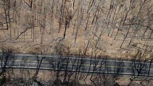 航拍直视下的乡村道路，旁边有一辆汽车和一条河视频素材