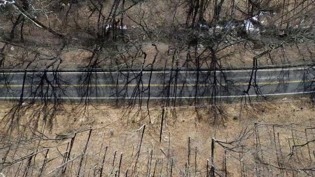 航拍直视下的乡村道路，旁边有一辆汽车和一条河视频素材