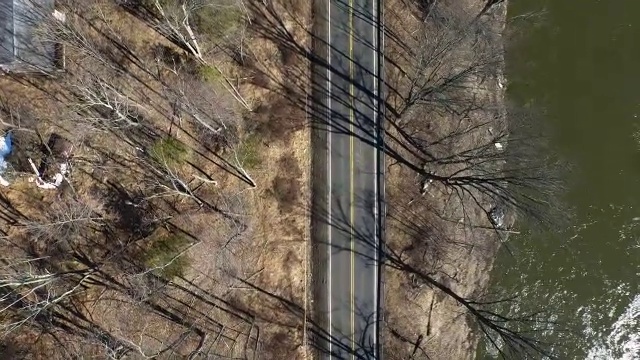 从空中俯瞰冬天的树木、道路和河流视频素材