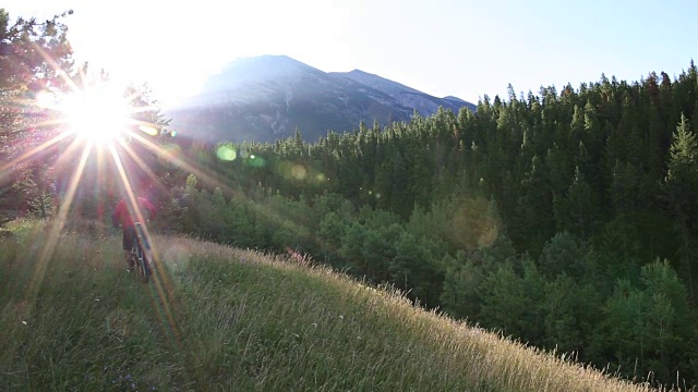 山地自行车沿着草地的路径，用智能手机拍照视频素材