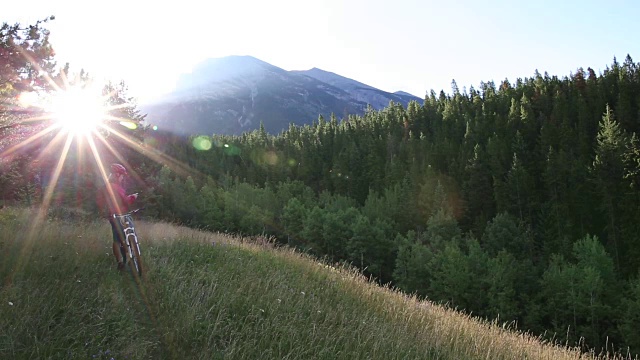 山地自行车沿着草地的路径，用智能手机拍照视频素材