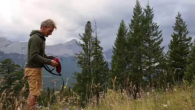 徒步旅行者穿过草地，眺望群山和森林视频素材