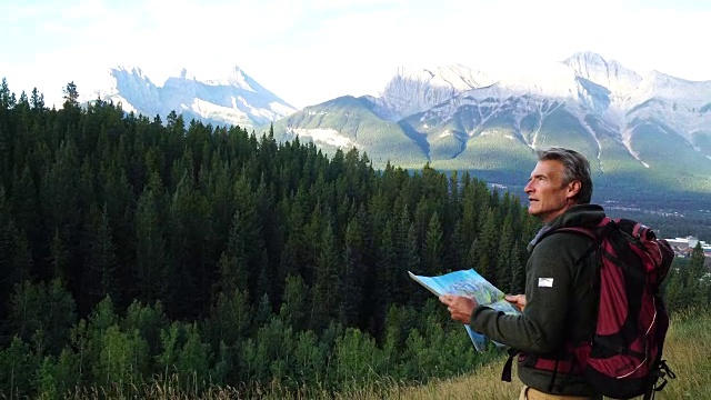 徒步旅行者穿过草地，眺望群山和森林视频素材