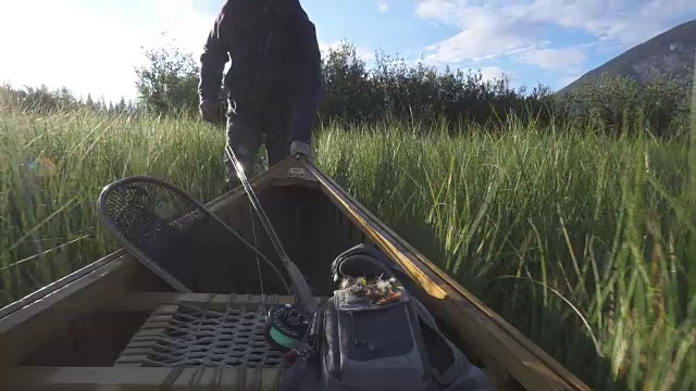 一名男子划着木独木舟进入山中湖泊视频素材