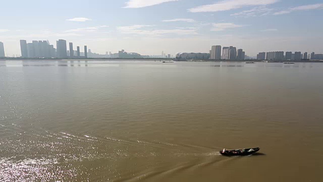 钱塘江上的一艘船，映衬着杭州市中心的天际线视频素材