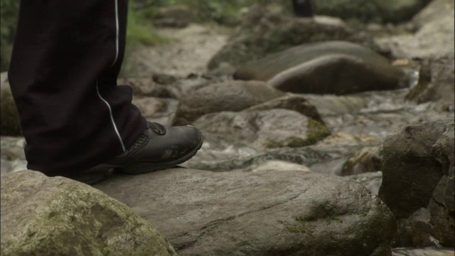 中国峨眉山，人们踏着石头过河视频素材