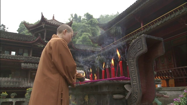 佛教僧人在神龛上点燃蜡烛。峨嵋山,中国视频素材